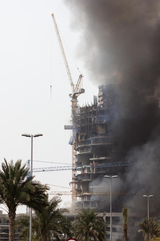 Thick, black smoke can be seen engulfing the building and billowing into the sky as the fire rages