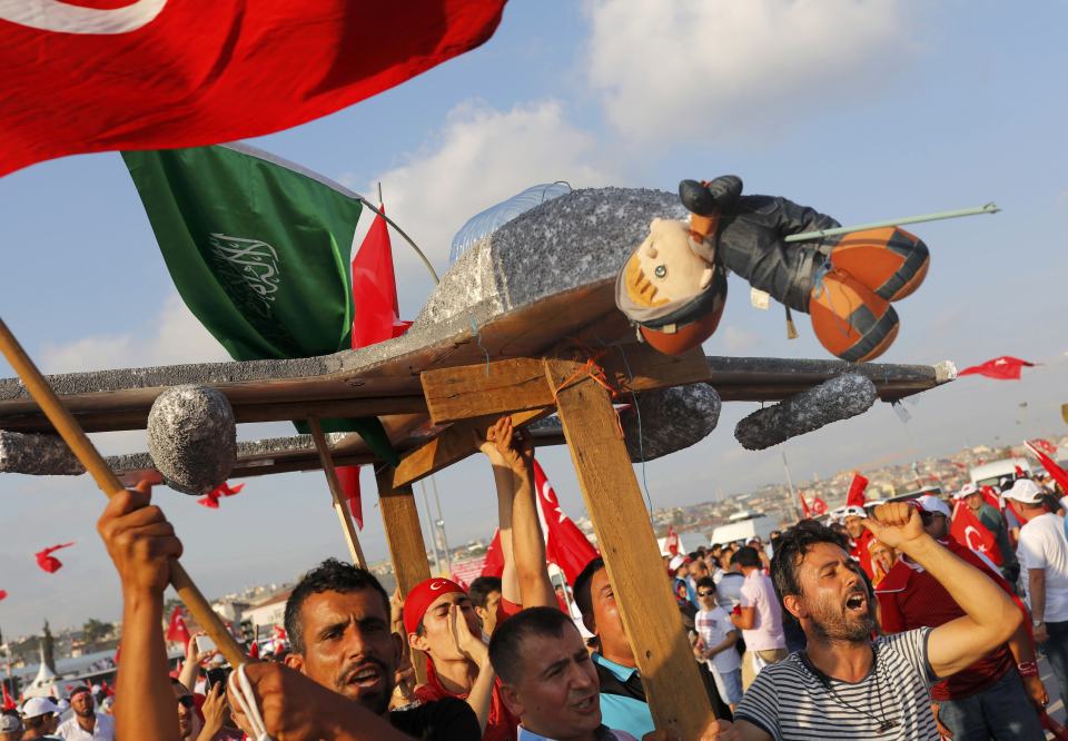 People hold a plane model with attached toy depicting oposition cleric in exile Gulen during the Democracy and Martyrs Rally in Istanbul