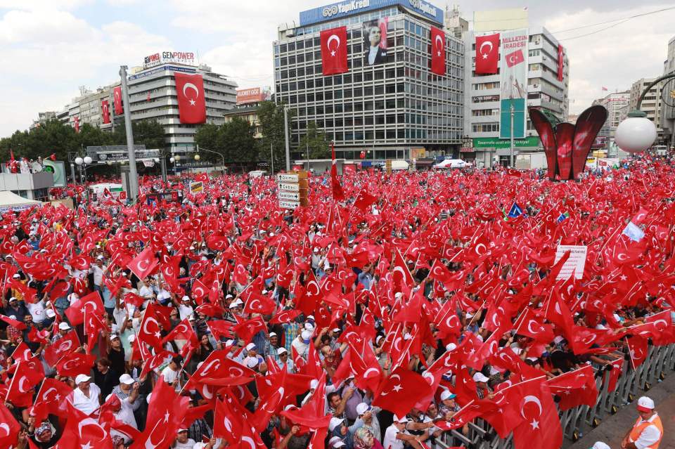 People wave Turkish national flags as th