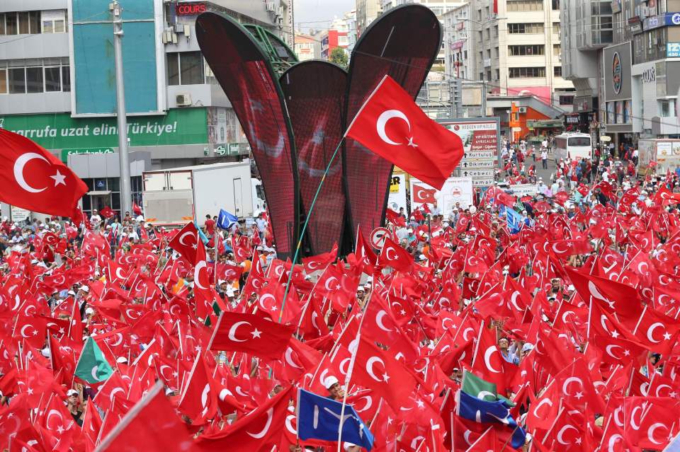 People wave Turkish national flags as th