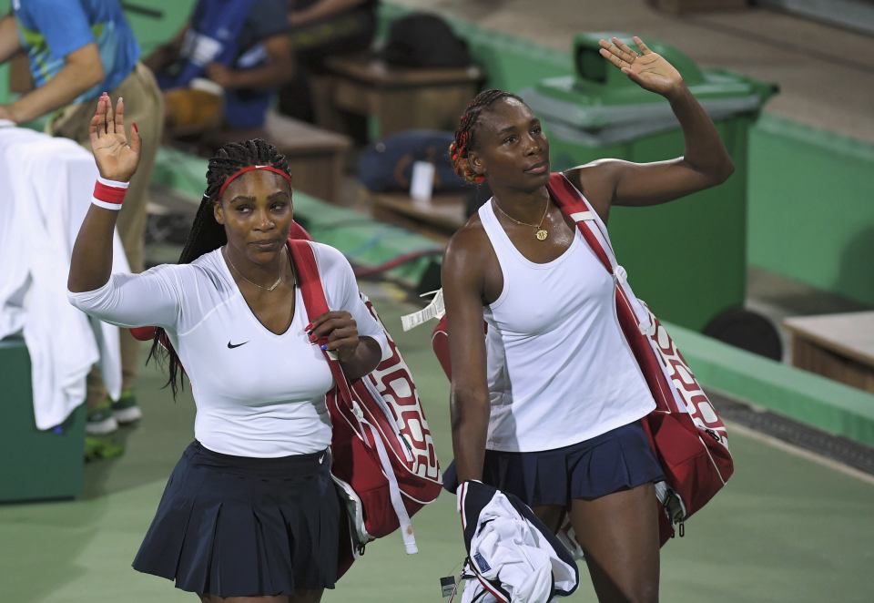 Serena and Venus Williams wave goodbye after they were knocked out in the first round