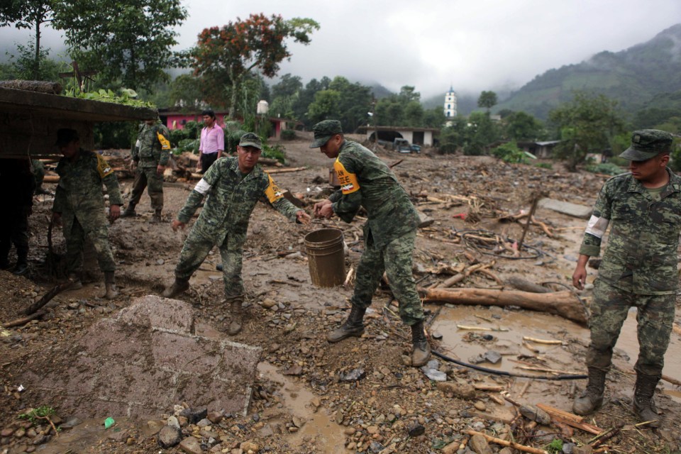  Mexican soldiers remove mud and debris from the remains of house destroyed by a mudslide in Xaltepec, on the mountainous north of Puebla state yesterday