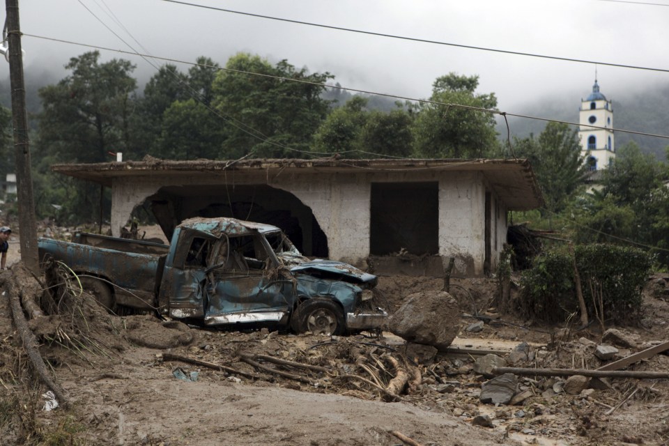  A pickup truck lays destroyed next to a house damaged by a mudslide in Xaltepec, on the mountainous north of Puebla state