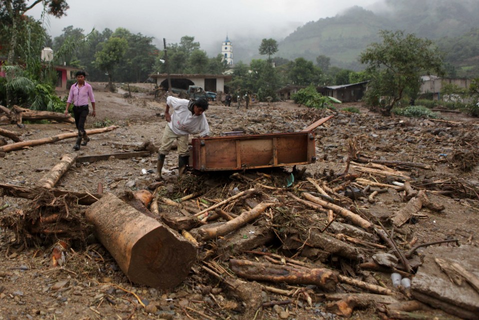  A man inspects furniture that was dragged out by a mudslide following a torrential downpour