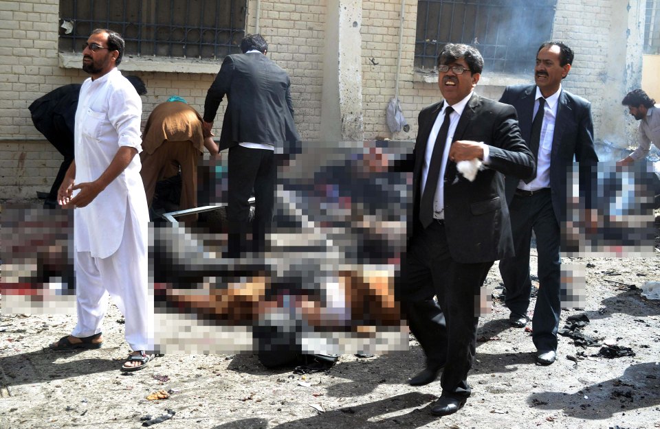  Pakistani lawyers react as the walk near the bodies of their colleagues at the site of a bomb explosion at a government hospital premises