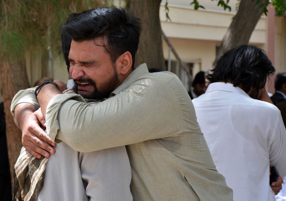  Pakistani relatives mourn next to bodies of victims after the attack hit the southwest hospital