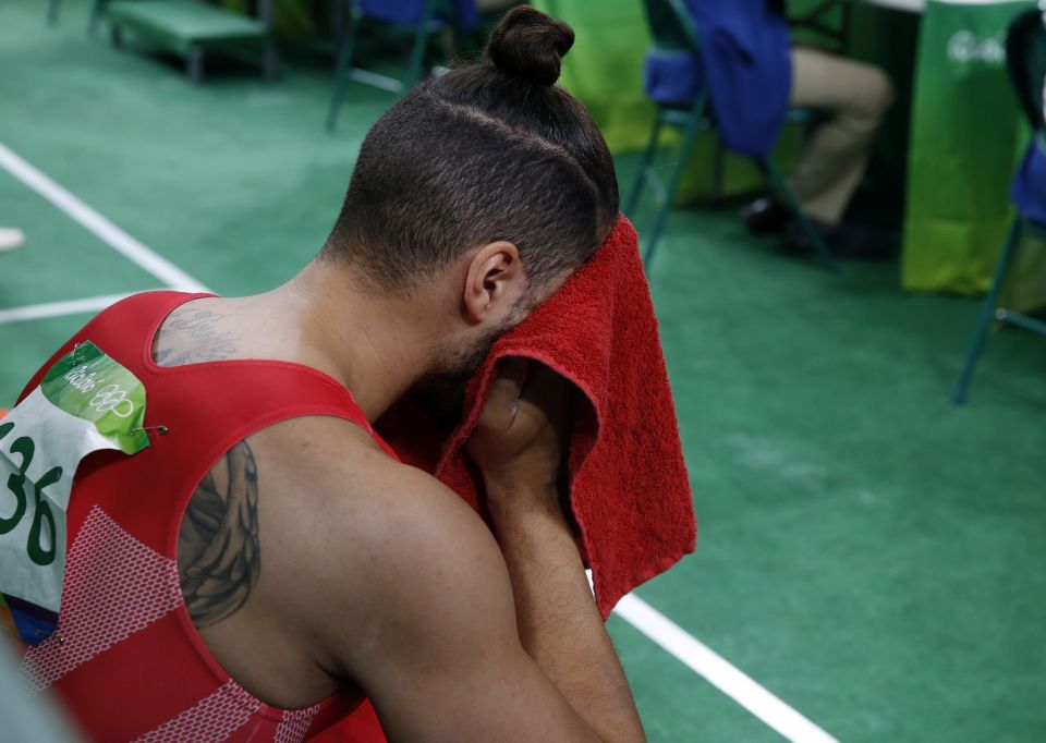  Louis Smith hides his face behind a towel after falling off the pommel horse