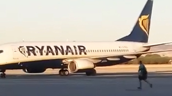 The Ryanair passenger runs along the tarmac at Madrid airport after nearly missing his flight