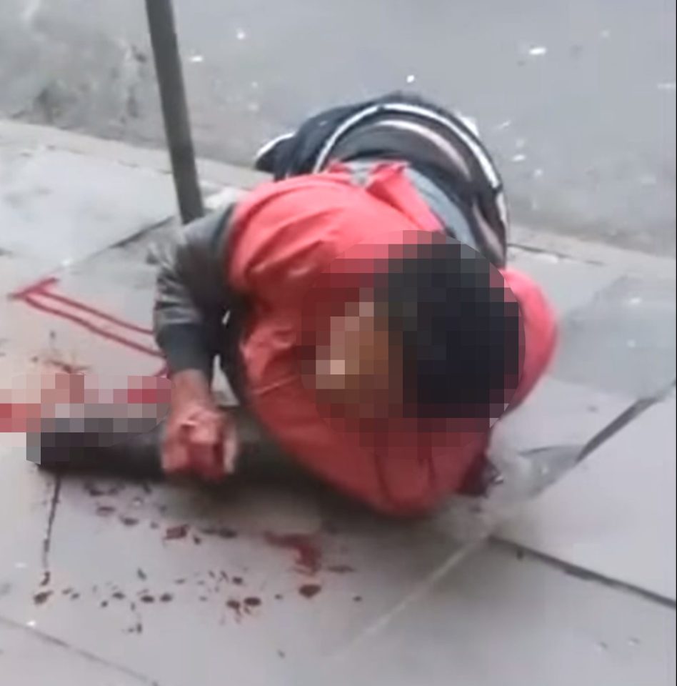 The suspected thief lies on the pavement after his hand was chopped off