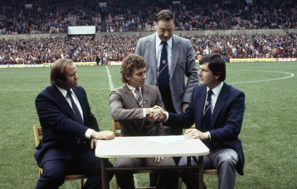 Bryan Robson signs for Manchester United on the pitch prior to a match against Wolverhampton Wanderers at Old Trafford in 1981