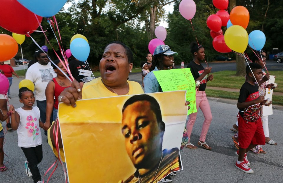 Sharon Cowan chants as she marches on the way to a candle light vigil on the spot where Mike Brown was killed on Tuesday, Aug. 9, 2016, in Ferguson. The protest was disrupted when a protester was hit by a car