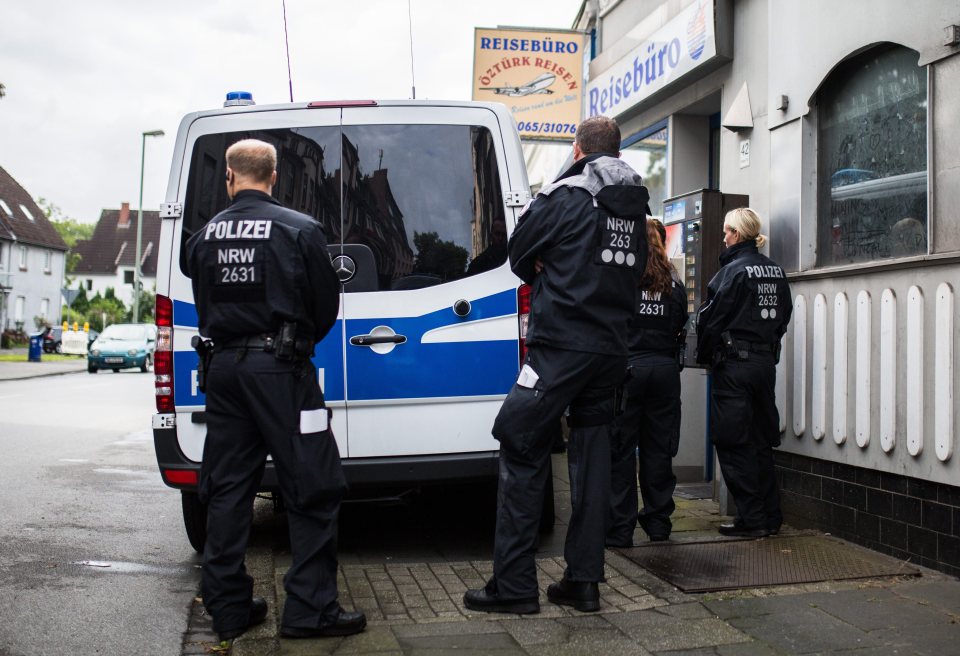 Police are pictured outside a Turkish travel agent store in Duisberg, Germany this morning