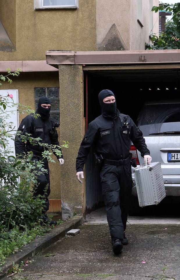 Police leave a house in Hildesheim, Germany, carrying items of interest