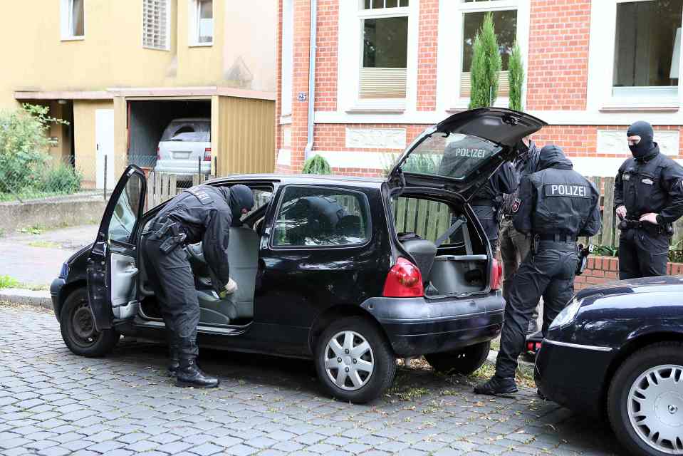 Cops search a car during the anti-terror raids carried out this morning