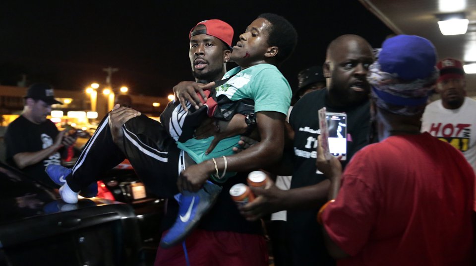 The man hit by a car during the Michael Brown protests is carried to safety 