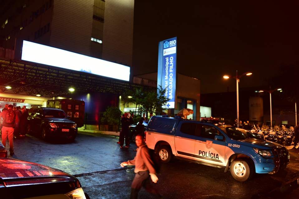 Cops waits to hear information about Helio outside a hospital where he underwent surgery