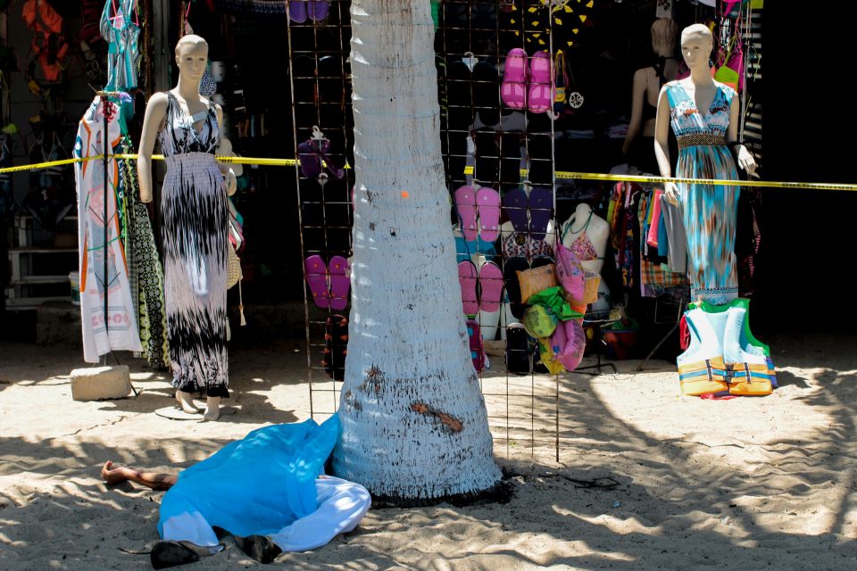  A body lies on the beach in Acapulco just outside tourist shops