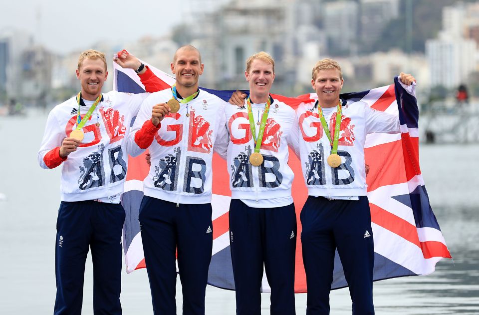 The men's coxless fours proudly show off their gold medal