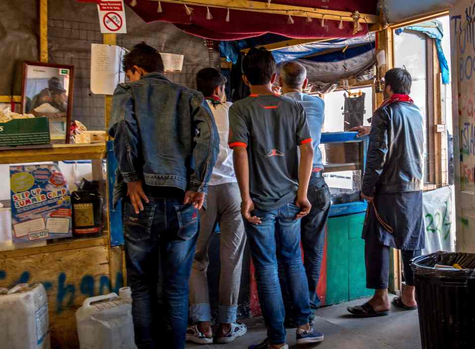  People queuing up in a restaurant within the Calais Jungle, which apparently has its own micro-economy