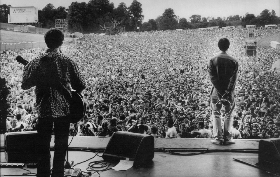 A black and white photo of Oasis performing at Knebworth