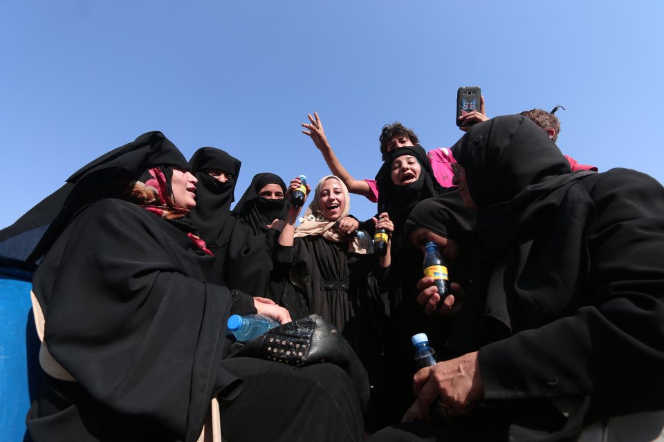  Woman and children celebrate as the death cult are forced out of their town