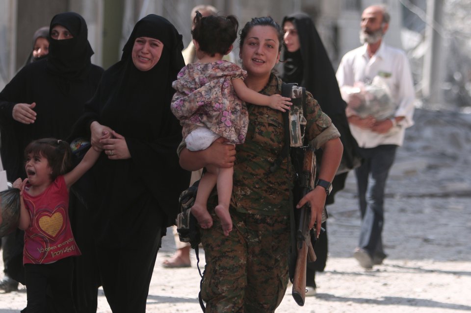  A SDF fighter helps civilians who were evacuated from an ISIS controlled neighbourhood