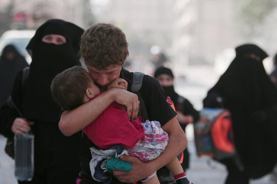  A civilian man holds a child closely after the extremist group ISIS fled Manbij in northern Syria