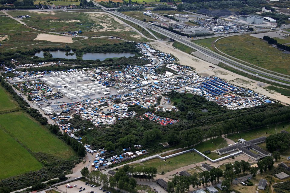 Aerial view of a makeshift camp as containers (rear) are put into place to house migrants living in what is known as the "Jungle", a sprawling camp in Calais