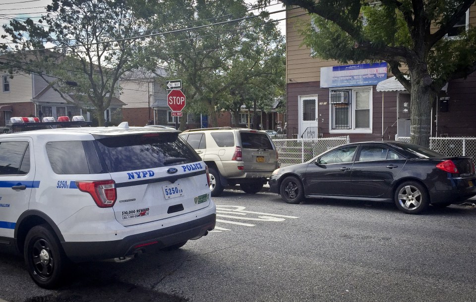  A police vehicle is parked across the street from the Al-Furqan Jame Masjid mosque, where two men had just left before they were murdered