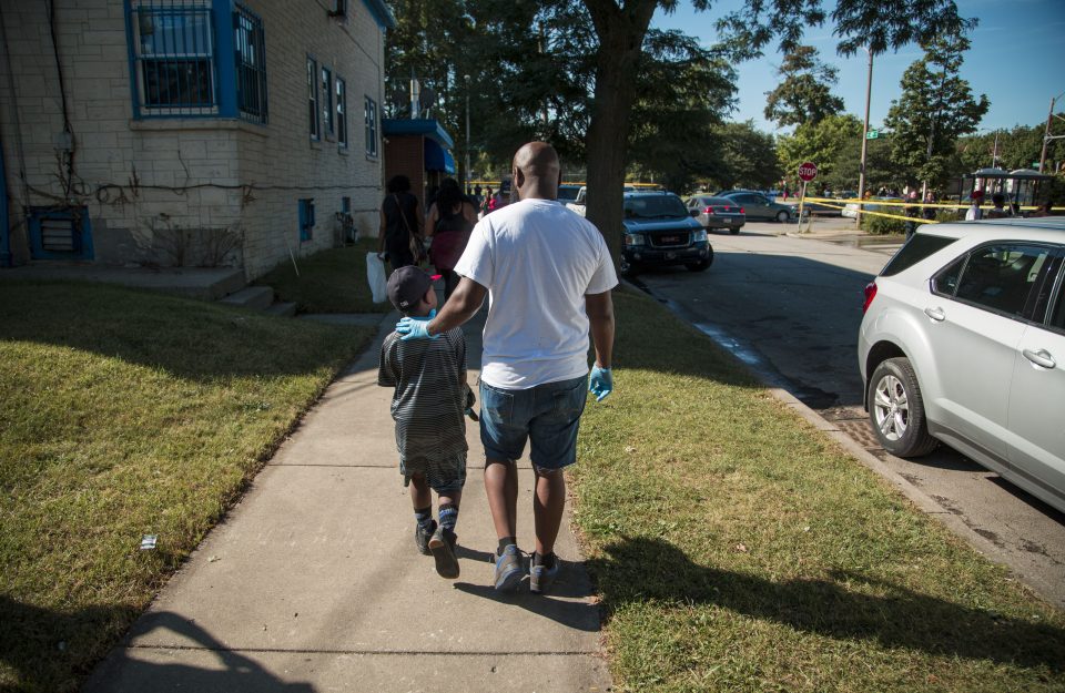  A man walks with his son past a damaged BP gas station