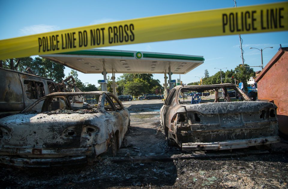  Cars stand decimated in the lot of a BP gas station