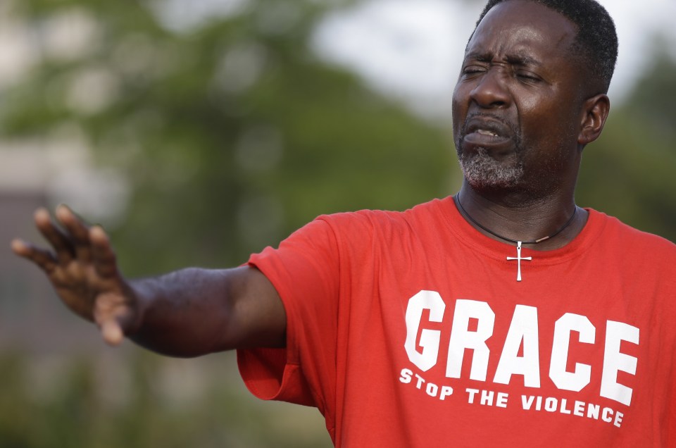  A man appeals for calm outside one of the damaged businesses