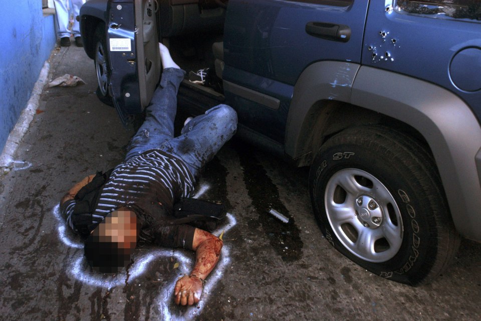  A dead gang member lies on the street in the popular tourist resort