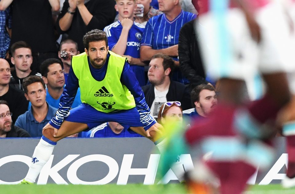 Cesc Fabregas has a stretch on the touchline during Chelseas game with West Ham