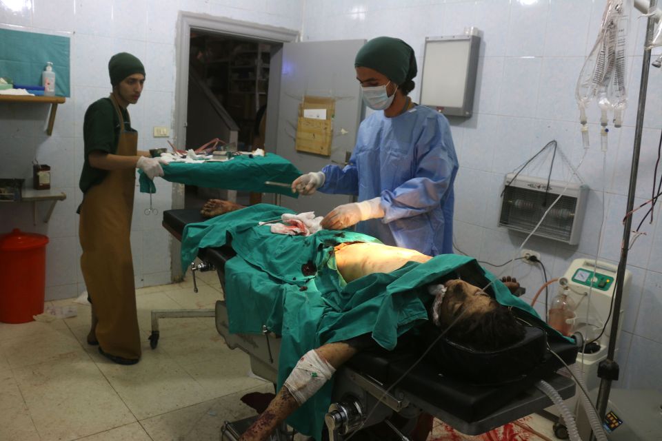  Syrian medics treat a man at a makeshift hospital in the Tariq al-Bab neighbourhood of Aleppo, after he was wounded during reported air raids that targeted rebel-held areas in the northern city