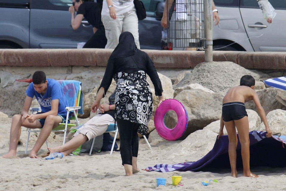  A Muslim woman wears a burkini, a swimsuit that leaves only the face, hands and feet exposed, on a beach in Marseille, France