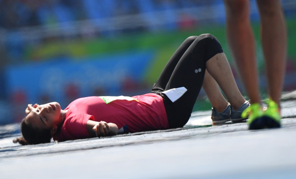 Egypt's Fatma Nagib El Sharnouby lies on the track after fainting in the heat