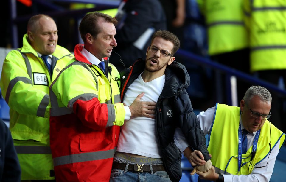 A spectator is restrained after the heated exchanges after the match