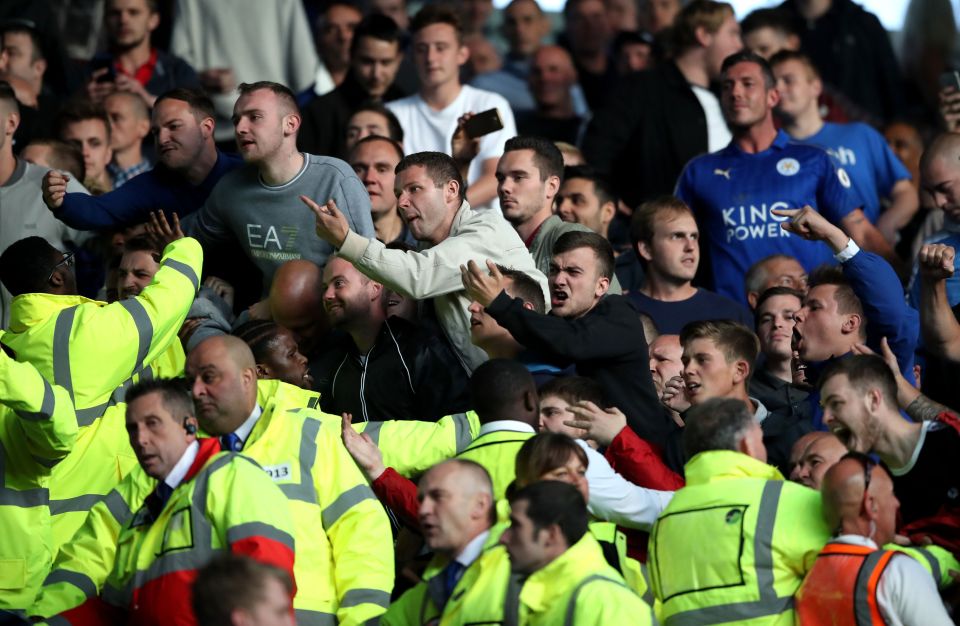 Supporters are held back after a heated exchange at the end of the match