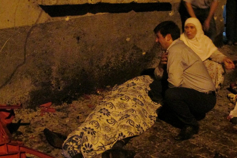  A man and a woman mourn next to a body of one the victim