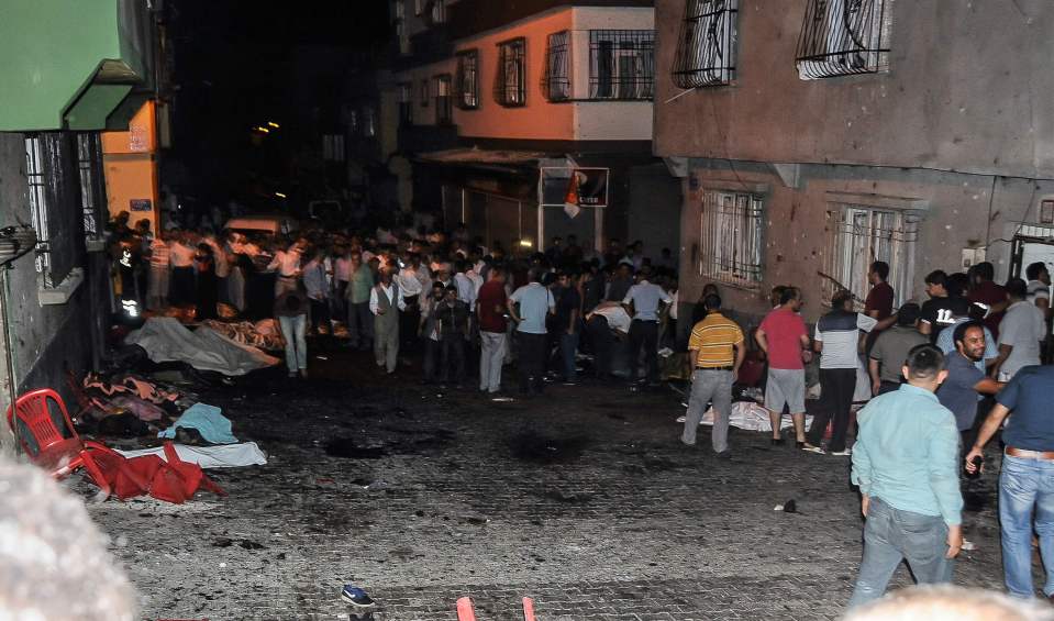  Bodies are covered as people gather at the explosion site