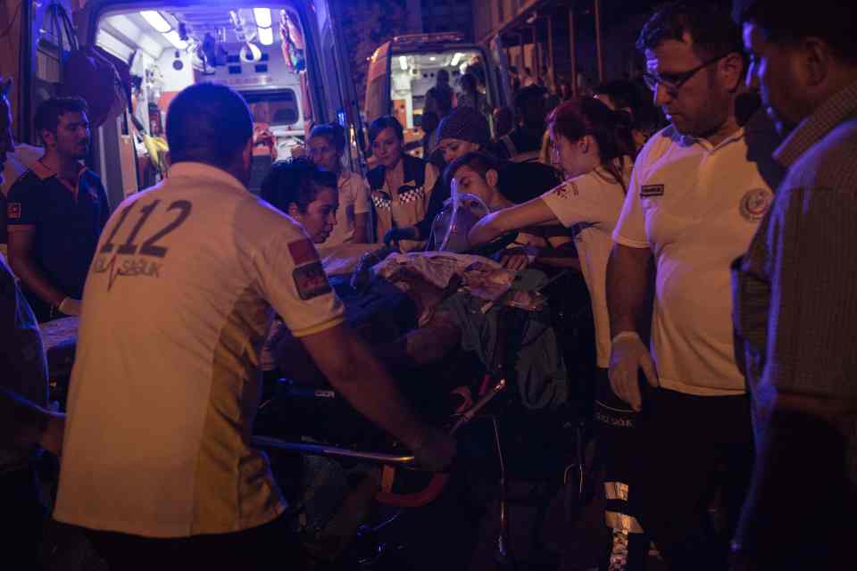  First aid officers carry an injured man to hospital with dozens still in critical care