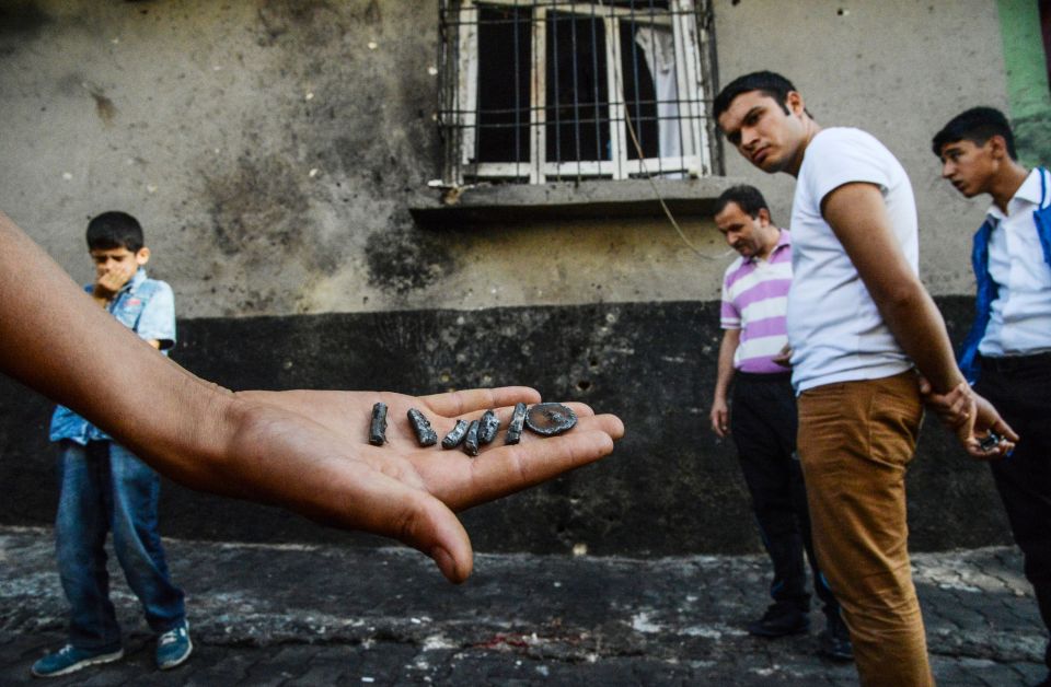  A person shows pieces of projectile near the explosion scene