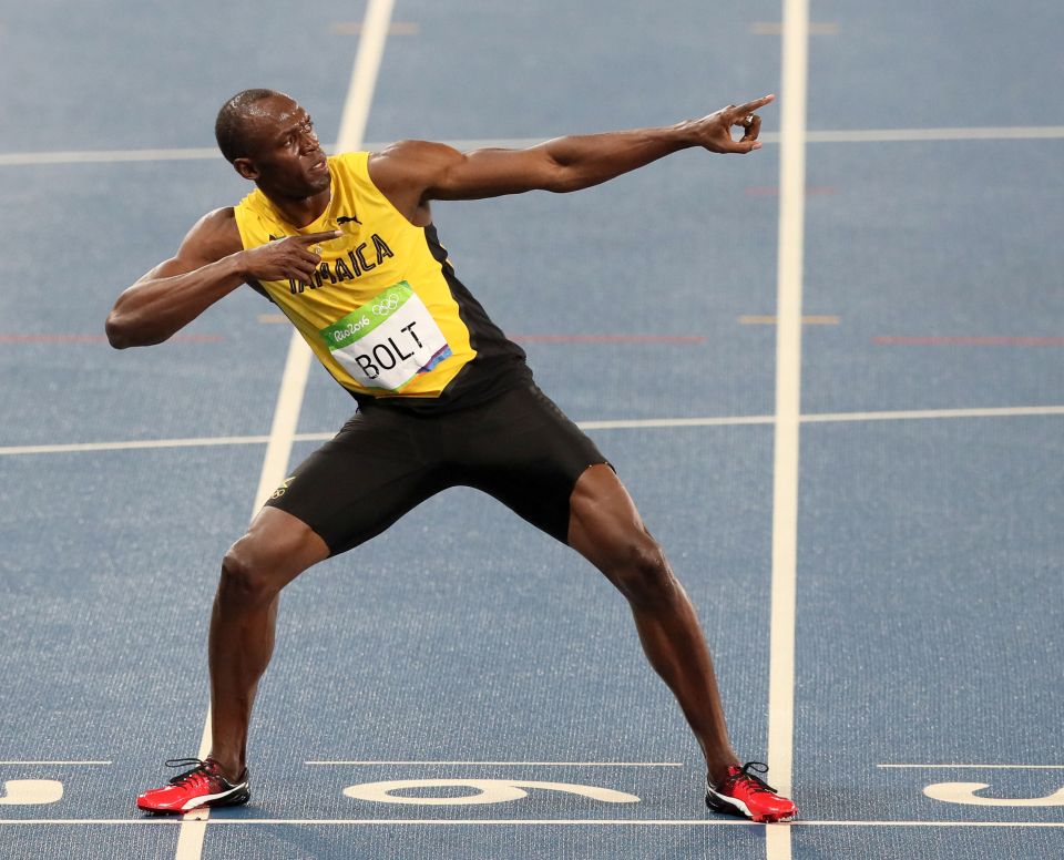 Usain Bolt celebrates by performing his trademark lightning bolt pose