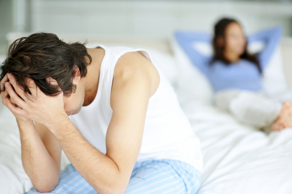 Frustrated man sitting on edge of bed