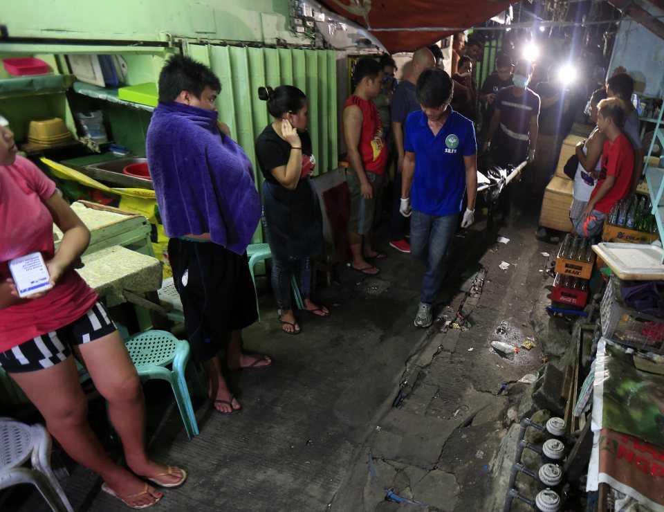  The body of one pusher is carried through a local market as traders watch the corpse move on by