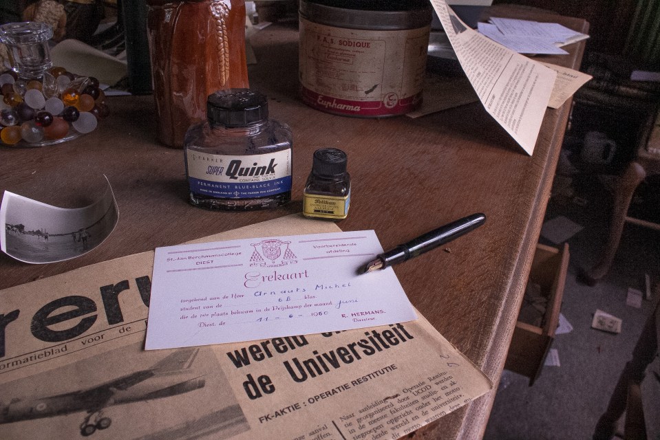 A handwritten note lies on a newspaper turned yellow with age