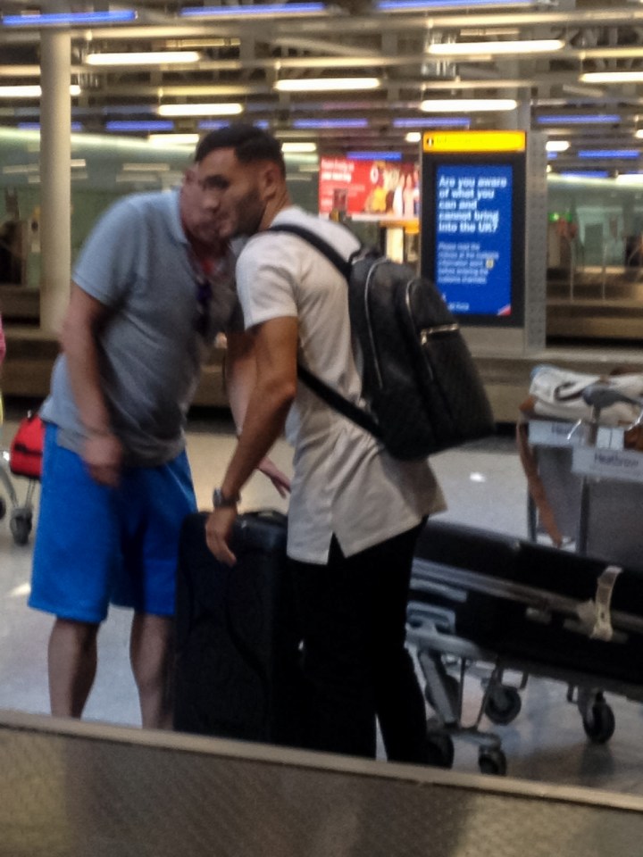 Lucas Perez picks up his bags after landing at Heathrow airpiort