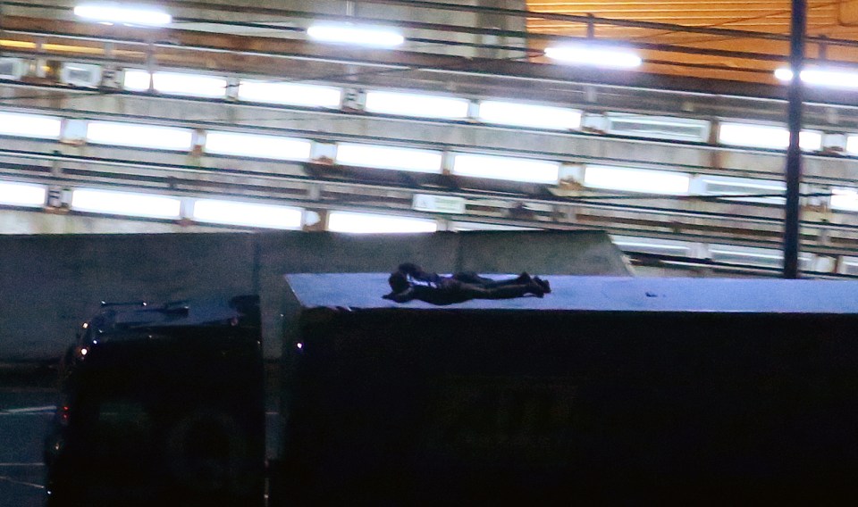  Migrants cling to the top of a lorry leaving the Eurotunnel site in Kent