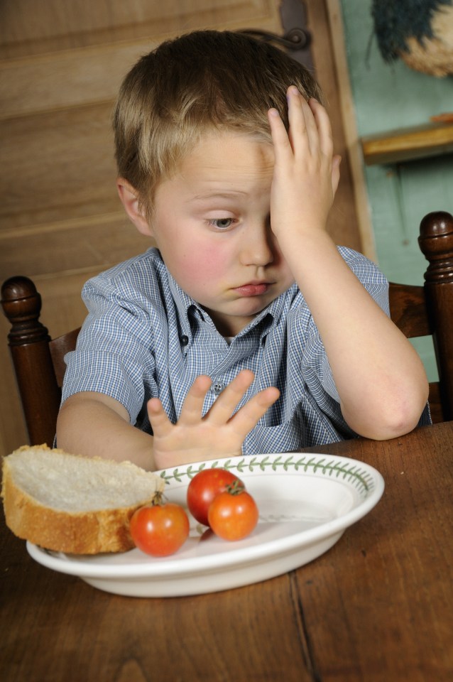 Boy (9 years old) not wanting to eat a plate of tomatoes and bread